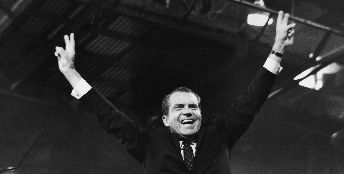 Richard Nixon en un mitin haciendo su habitual gesto de la victoria
